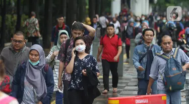 Pekerja berjalan kaki saat jam pulang di kawasan Sudirman, Jakarta, Jumat (7/2/2020). BPJS Ketenagakerjaan yang kini bernama BP Jamsostek menargetkan sekitar 23,5 juta tenaga kerja baru masuk dalam daftar kepesertaan pada 2020. (Liputan6.com/Angga Yuniar)