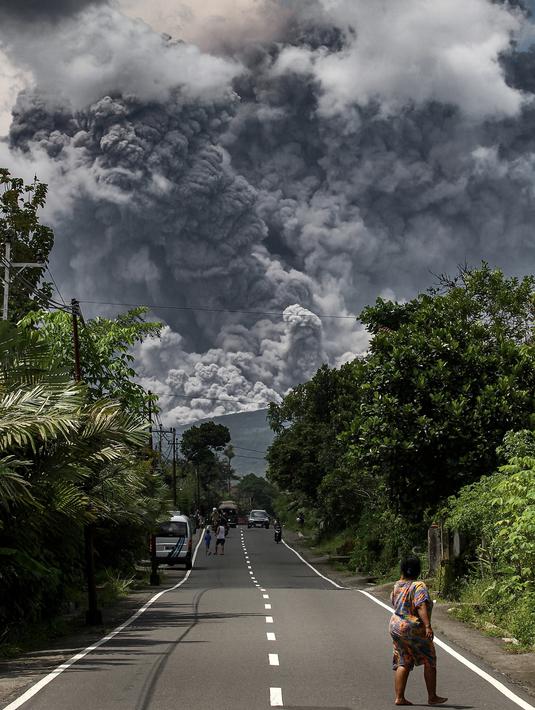 Warga melihat asap tebal mengepul saat erupsi Gunung Merapi terlihat dari desa Tunggularum di Sleman pada 11 Maret 2023. Kepala Balai Penyelidikan dan Pengembangan Teknologi Kebencanaan Geologi (BPPTKG) Agus Budi Santoso melalui keterangan resmi di Yogyakarta, Sabtu, mengatakan awan panas guguran terjadi pada pukul 12.12 WIB. Dia menyebut erupsi Gunung Merapi masih berlangsung.(AFP/Devi Rahman)