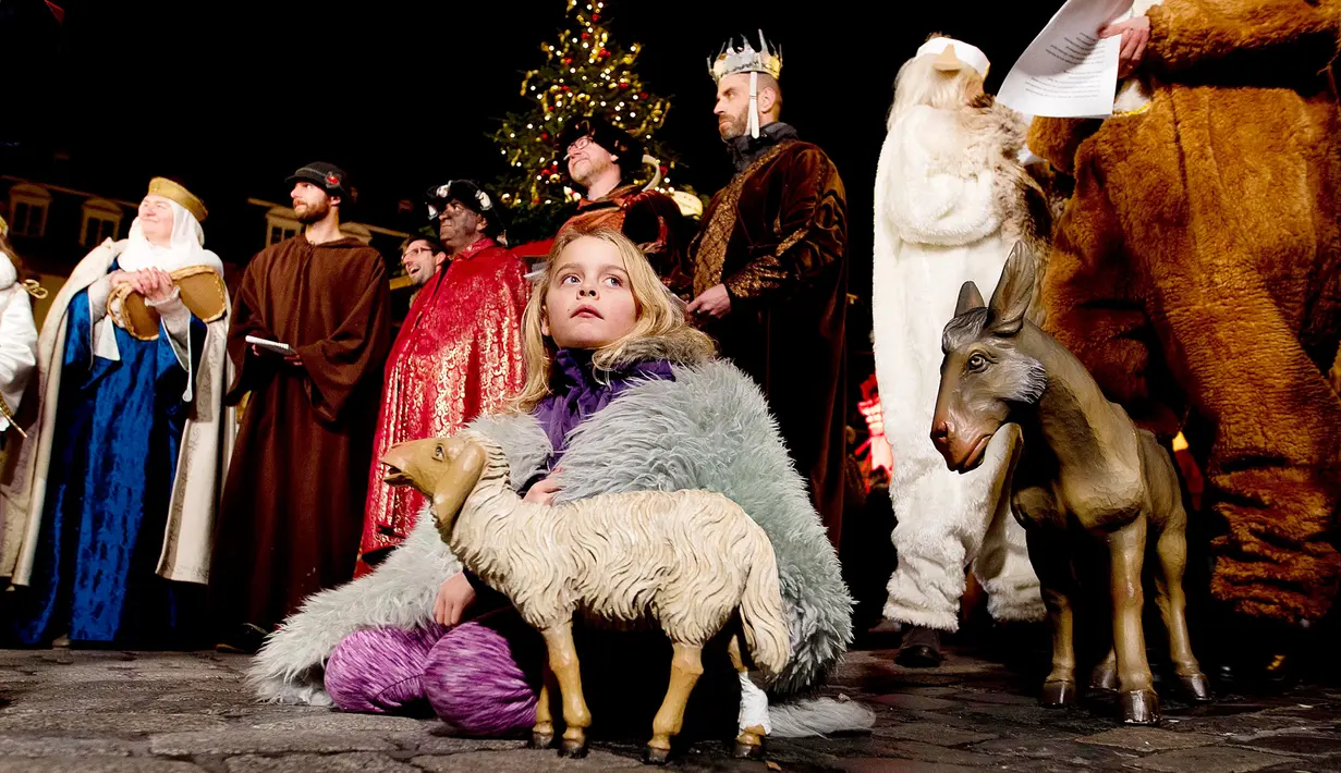 Seorang gadis duduk di tanah saat tampil dalam pertunjukan pasar Natal tradisional di Kota Tua Heidelberg, Jerman, Selasa (4/12). (AP Photo/Michael Probst)