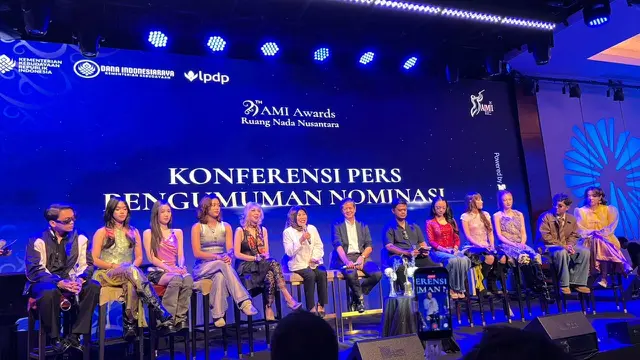 Ibu Irini Dewi Wanti, S.S., M.SP, berbicara sambil memegang mic, dalam konferensi pers AMI Awards yang diselenggarakan di Jakarta, (21/9/2026). (Liputan6.com/Afradhiya N. R)