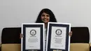 Gadis asal India, Nilanshi Patel (17) berpose dengan sertifikat Guinness World Records 2018 (kiri) dan 2019 sebagai rambut terpanjang dari kategori remaja di kota Modasa, sekitar 110 Km dari Ahmedabad, Minggu (19/1/2020). (SAM PANTHAKY/AFP)