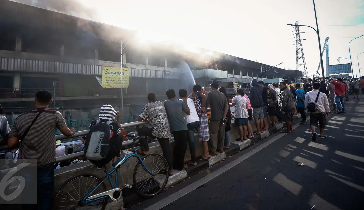 Warga tampak ramai melihat proses pemadaman kebakaran yang melanda pusat perbelanjaan Pasar Senen, Jakarta Pusat, Kamis (19/1). Kebakaran hebat di Pasar Senen sementara diduga karena terjadinya korsleting listrik. (Liputan6.com/Faizal Fanani)