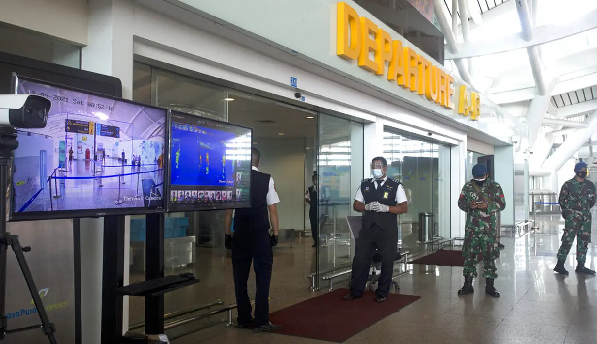 <p>Pekerja berjaga dekat pemindai termal saat latihan pembukaan kembali Bandara Internasional Ngurah Rai di Bali, Sabtu (9/10/2021). Indonesia berencana kembali membuka Bandara Internasional Ngurah Rai untuk penerbangan internasional pada 14 Oktober 2021. (AP Photo/Firdia Lisnawati)</p>