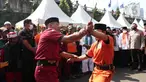 Dua warga beradu saat menampilkan pertunjukan kesenian bela diri asli Betawi Palang Pintu dalam Lebaran Tenabang 2022 di kawasan Tanah Abang, Jakarta, Sabtu (4/6/2022). Kegiatan yang menampilkan berbagai kesenian Betawi, makanan tradisional, perlombaan, dan bazar UMKM itu mengangkat tema KolaborAksi. (Liputan6.com/Angga Yuniar)