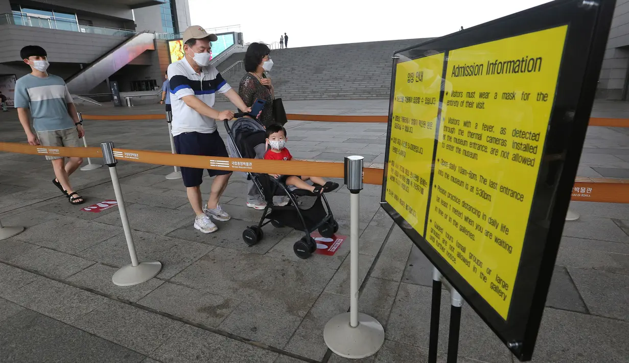 Pengunjung yang mengenakan masker memasuki ruang pameran di Museum Nasional Korea di Seoul, Korea Selatan, Rabu (22/7/2020). Museum ini dibuka kembali pada Rabu (22/7) setelah ditutup selama dua bulan akibat pandemi corona Covid-19. (AP Photo/Ahn Young-joon)
