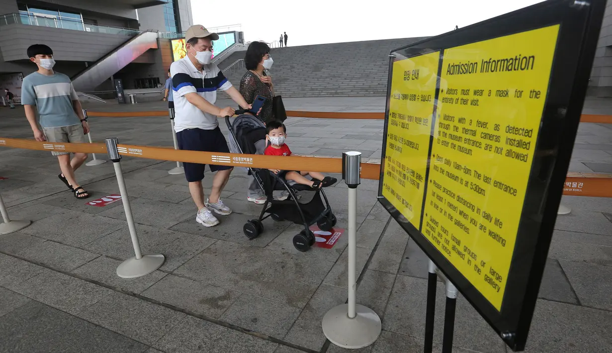 Pengunjung yang mengenakan masker memasuki ruang pameran di Museum Nasional Korea di Seoul, Korea Selatan, Rabu (22/7/2020). Museum ini dibuka kembali pada Rabu (22/7) setelah ditutup selama dua bulan akibat pandemi corona Covid-19. (AP Photo/Ahn Young-joon)