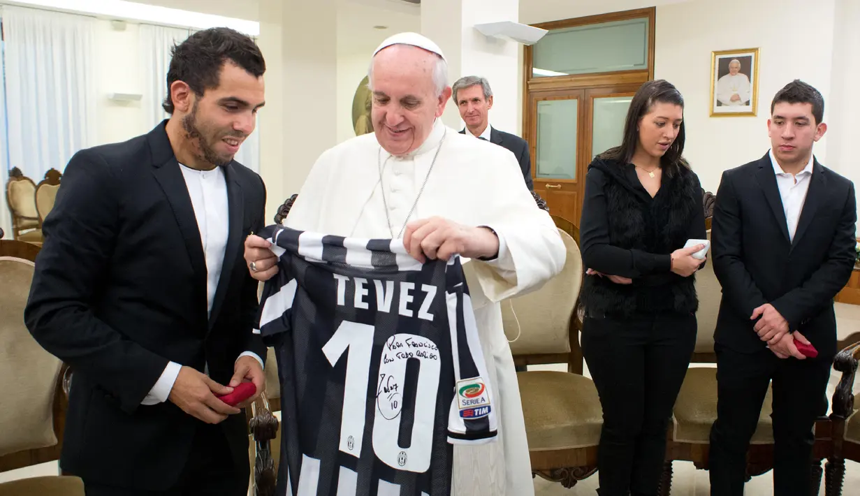 Paus Fransiskus memegang jersey dari pemain Juventus, Carlos Tevez selama audiensi pribadi di Vatican 12 November 2013. (AFP/Osservatore Romano)