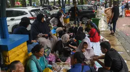Meski diguyur hujan deras, sejumlah pengunjung tetap menyusuri area Kebun Binatang Ragunan, Jakarta. (merdeka.com/Arie Basuki)