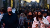 Pejalan kaki melintas di jalan perbelanjaan Roma, Italia pada Kamis (23/12/2021). Pemerintah Italia telah mewajibkan kembali penggunaan masker di luar ruangan untuk menahan peningkatan kasus Covid-19 yang didorong oleh varian Omicron. (Filippo MONTEFORTE/AFP)