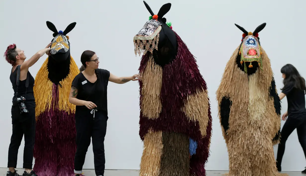 Para tim sedang mempersiapkan kostum menyerupai kuda karya Nick Cave yang akan ditampilkan di Sydney, Australia (8/11). Kostum ini terinspirasi dari tekstil Tibet dan pakaian upacara tradisional Afrika. (Reuters/Jason Reed)