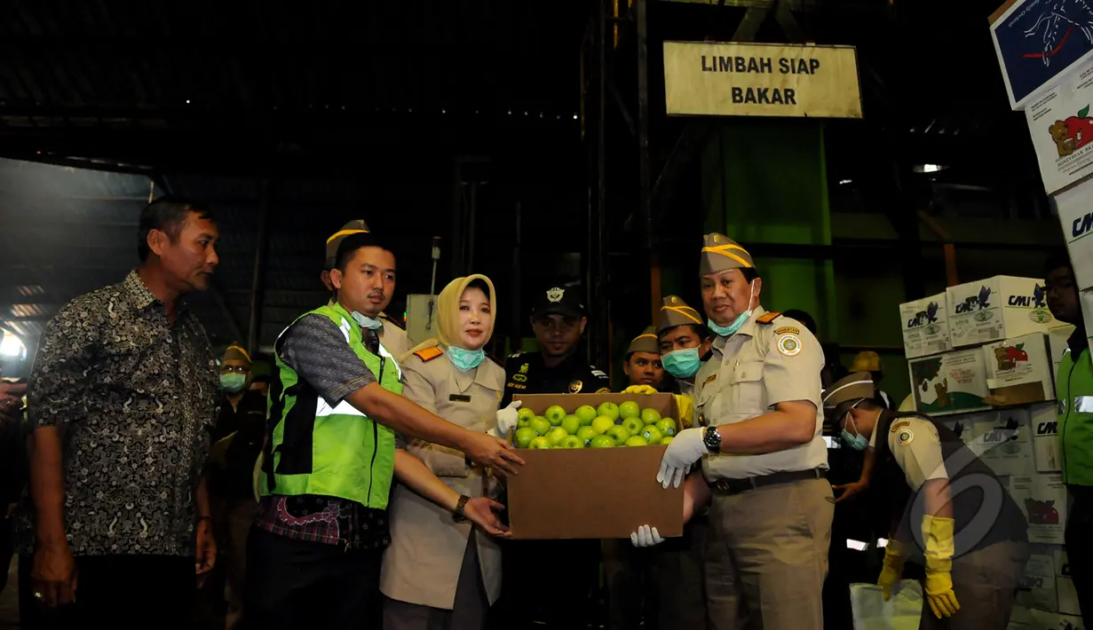 Sejumlah petugas dari Badan Karantina Kementerian Pertanian menunjukkan salah satu jenis apel tidak layak dan tidak aman makan untuk dimusnahkan dengan alat pembakar insenerator di Karawang, Jawa Barat, Jumat (6/3/2015). (Liputan6.com/Helmi Fithriansyah)