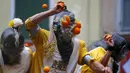 Seorang peserta dilempari jeruk saat perang-perangan selama karnaval di kota Ivrea, Italia, Minggu (7/2). Peserta yang dibagi menjadi dua tim ini saling melempar jeruk menggunakan kostum dan aksesoris lengkap. (REUTERS/Stefano Rellandini)