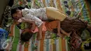 Anak Tertidur ditemani pengasuh di rumah singgah Yayasan Kasih Anak Kanker Indonesia, Jakarta, Senin (15/2). Setiap tahun diperkirakan 250.000 anak terdiagnosis kanker dan 90.000 diantaranya meninggal. (Liputan6.com/Faizal Fanani)