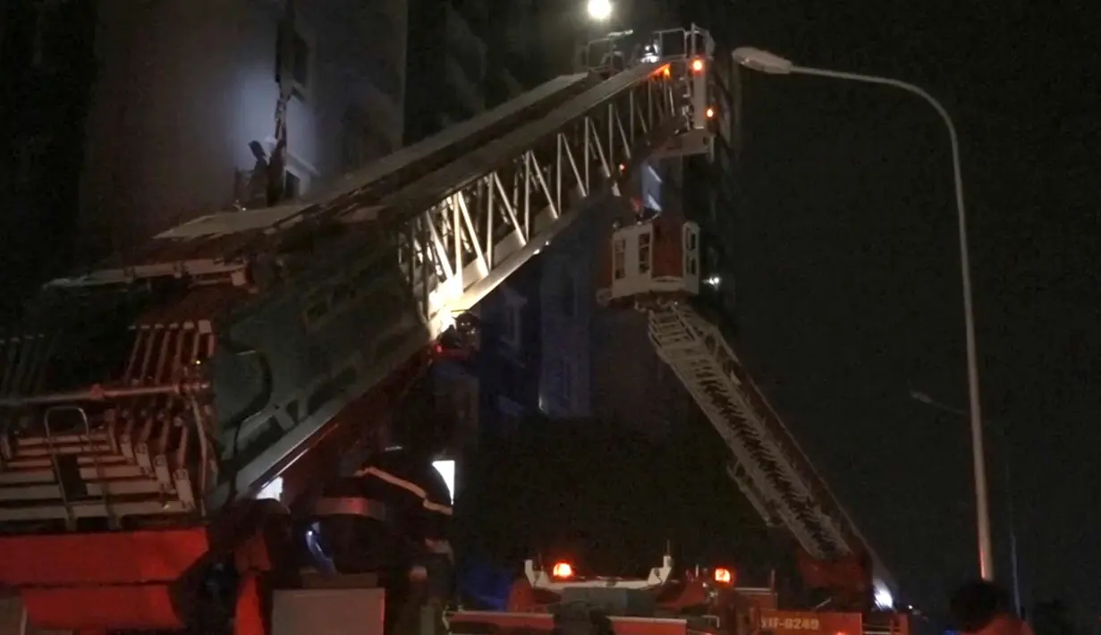 Crane digunakan untuk menyelamatkan orang-orang dari kompleks kondominium selama kebakaran di Kota Ho Chi Minh, Vietnam, (23/3). Kebakaran tersebut menewaskan belasan orang karena kehabisan nafas atau melompat dari lantai tinggi. (VnExpress via AP)