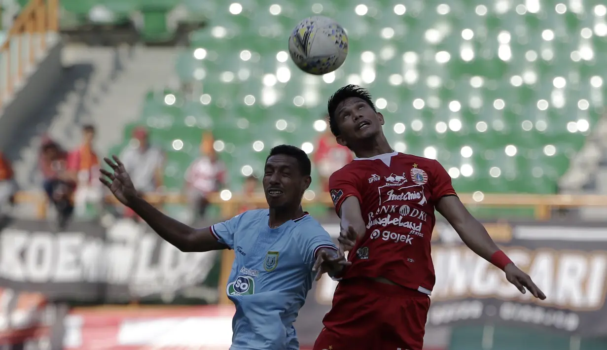 Gelandang Persija Jakarta, Sandi Sute, berebut bola atas dengan striker Persela Lamongan, Delfin Rumbino, pada laga Shopee Liga 1 di Stadion Wibawa Mukti, Bekasi, Jumat (15/11). Persija menang 4-3 atas Persela. (Bola.com/Yoppy Renato)