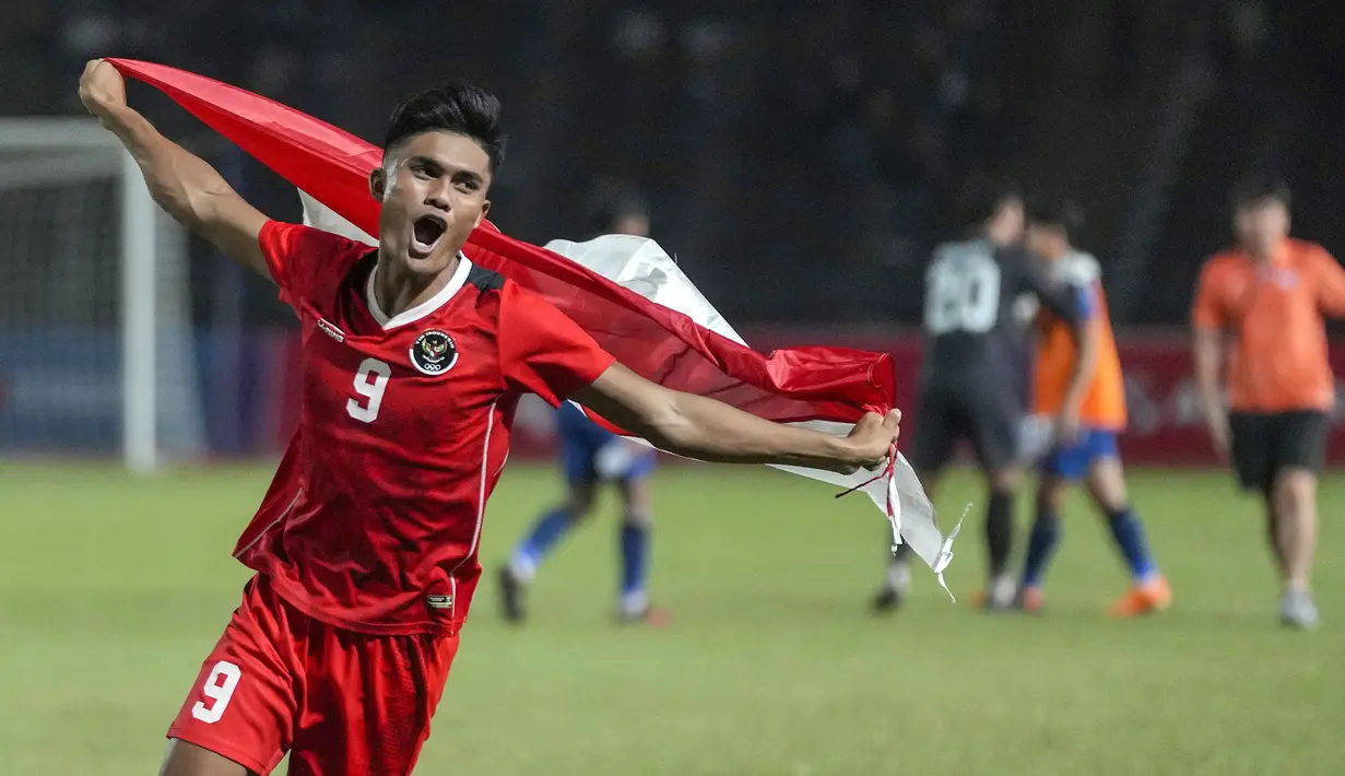 Pemain Timnas Indonesia U-22, Ramadhan Sananta merayakan kemenangan dengan membawa bendera Merah Putih pada laga final sepak bola SEA Games 2023 melawan Thailand di Olympic Stadium, Phnom Penh, Kamboja, Selasa (16/05/2023). Skuad Garuda Nusantara menang dengan skor 5-2. (AP Photo/Tatan Syuflana)