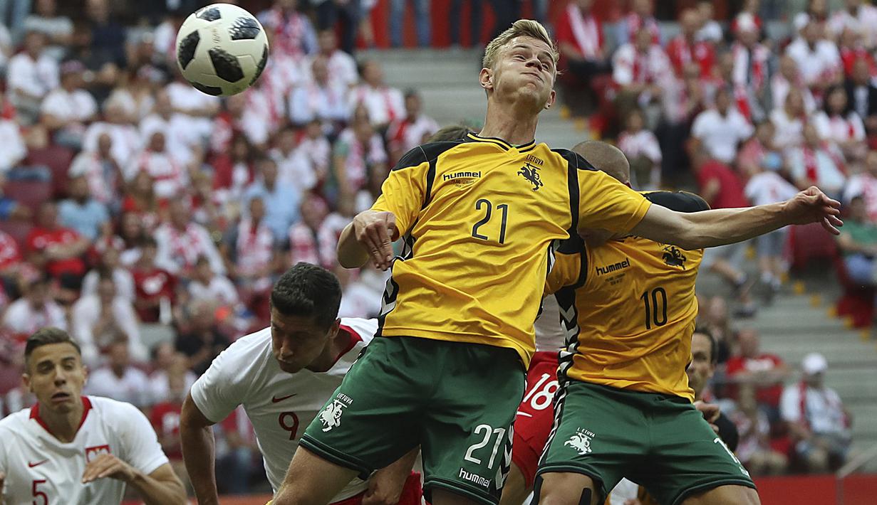 Duel pemain Polandia, Robert Lewandowski dengan pemain Lituania, Justas Lasickas pada laga uji coba di Stadion Narodowy, Warsaw, Polandia, (12/6/2018). Polandia menang 4-0. (AP/Czarek Sokolowski)