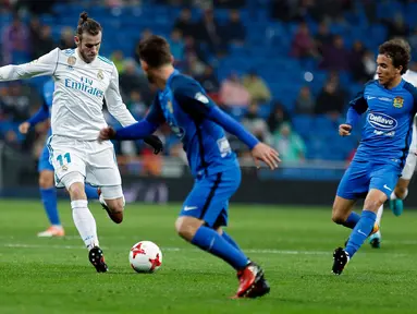 Pemain Real Madrid, Gareth Bale menggiring bola dengan kawalan pemain Fuenlabrada pada laga Copa del Rey 2017-2018 di Stadion Santiago Bernabeu, Selasa (28/11). Madrid lolos ke 16 besar Copa del Rey, meski imbang 2-2. (AP Photo/Francisco Seco)