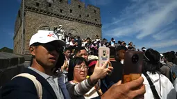 Pengunjung menyusuri anak tangga di Tembok China bersama keluarga maupun teman. (GREG BAKER / AFP)