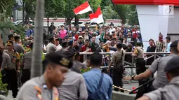 Massa aksi pendukung revisi Undang-Undang Komisi Pemberantasan Korupsi (KPK) mendatangi depan gedung lembaga antirasuah di Kuningan, Jakarta, Jumat (13/9/2019). Saat demonstrasi berlangsung, mereka membakar karangan bunga bernada dukungan dan keprihatinan terhadap KPK. (Liputan6.com/HO/Andri)