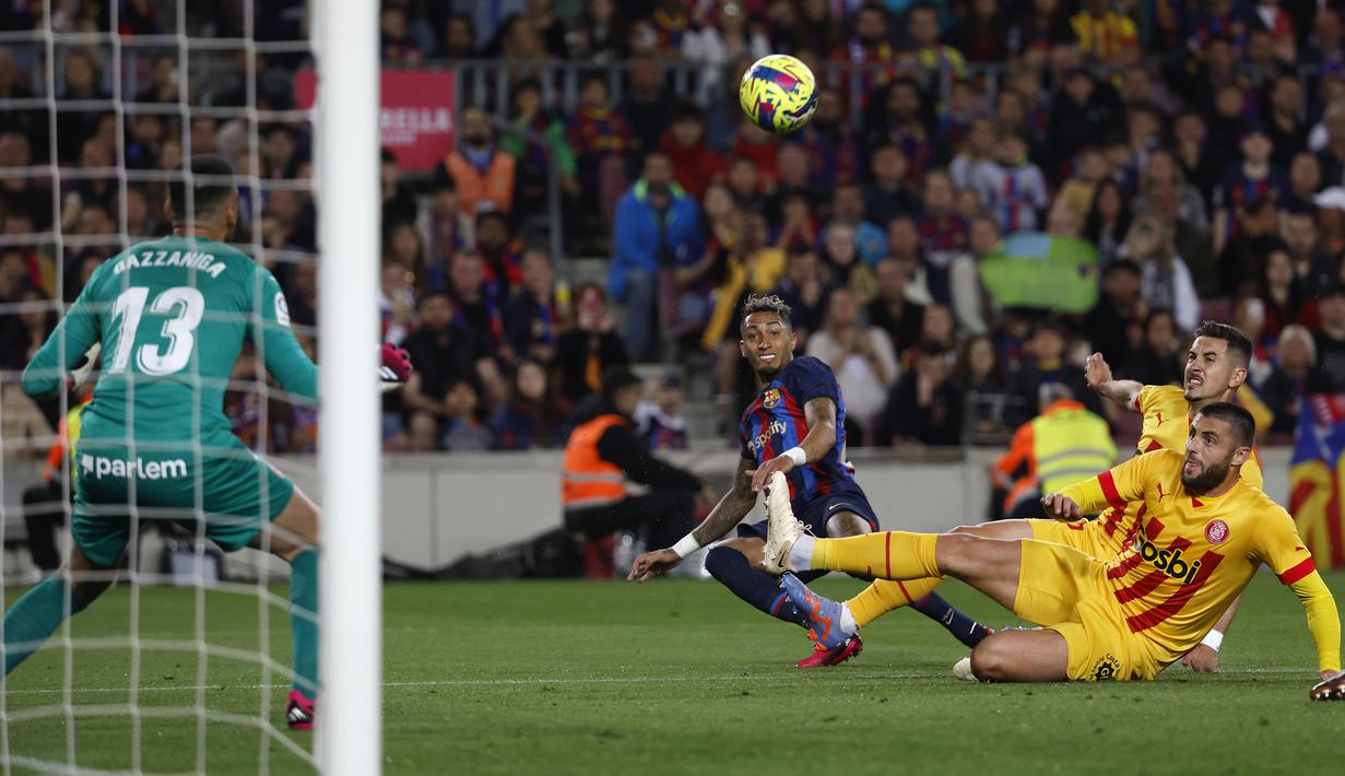 Striker Barcelona, Raphinha (tengah) melepaskan tendangan yang berusaha diblok bek Girona pada laga lanjutan pekan ke-28 Liga Spanyol 2022/2023 di Camp Nou Stadium, Barcelona, Selasa (11/4/2023) dini hari WIB. (AP Photo/Joan Monfort)