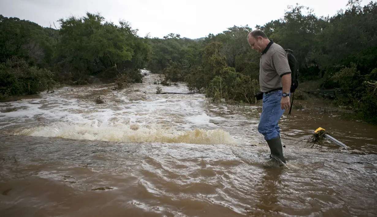 Seorang warga melintas dijalanan yang rusak akibat Tornado yang menyaou bagian kota Texas, Amerika Serikat, Jumat (30/10/2015). Tornando disertai hujan ini mengakibatkan Jalanan menjadi banjir dan sungai meluap. (REUTERS/Ilana Panich - Linsman)