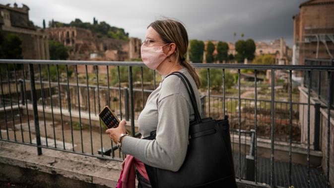 Seorang perempuan memakai masker saat dia berjalan di dekat Forum Romawi di Roma pada Sabtu (3/10/2020). Mulai Sabtu, masker wajah harus dipakai setiap saat di luar rumah di ibu kota Italia, Roma dan wilayah sekitar Lazio untuk meredam infeksi Covid-19 yang meningkat. (AP Photo/Andrew Medichini)