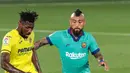 Pemain Villareal, Andre-Frank Zambo Anguissa berebut bola dengan gelandang Barcelona, Arturo Vidal dalam pekan ke-34 La Liga Spanyol di stadion La Ceramica, Minggu (5/7/2020). Barcelona sukses menumbangkan tim tuan rumah Villarreal dengan skor telak 4-1. (AP Photo/Jose Miguel Fernandez)