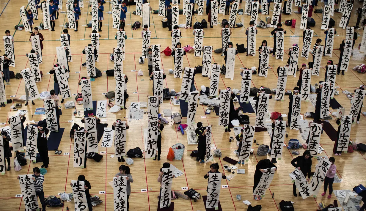 Peserta menunjukkan tulisan Jepang mereka saat mengikuti lomba kaligrafi Tokyo, Jepang (5/1). Lomba kaligrafi tulisan Jepang ini digelar setiap tahun yang diadakan pada awal tahun baru. (AFP Photo/Behrouz Mehri)