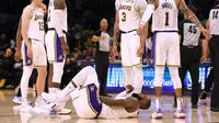 Pemain Lakers LeBron James terkapar memegangi alat vitalnya setelah dipukul pemain Grizzlies Dilon Brooks pada play-off NBA (AP)