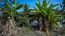 Atlet angkat besi Olimpiade dari Filipina, Hidilyn Diaz berlari melewati pohon pisang selama sesi Latihan di Jasin di kota Malaka, Malaysia pada 21 Mei 2021. Diaz (30) yang memenangkan perak di Rio 2016 lalu telah tertahan di Malaysia sejak Februari 2020 karena pandemi virus corona (Mohd RASFAN/AFP)