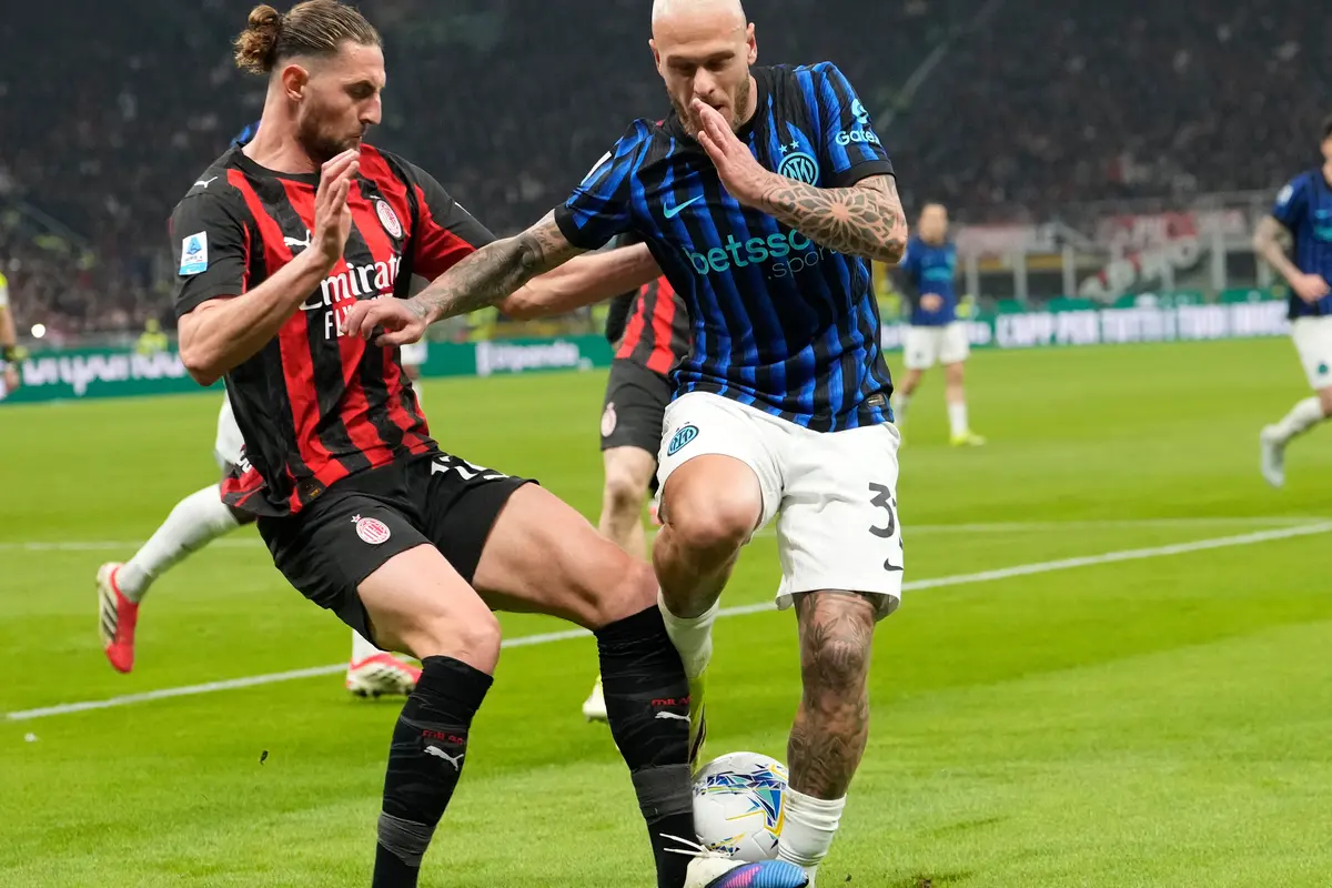 Pemain Inter Milan Federico Dimarco (tengah kanan) berebut bola dengan pemain AC Milan Adrien Rabiot