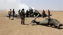 Pemberontak Suriah memeriksa reruntuhan helikopter milik Rusia yang ditembak jatuh di wilayah Idlib, Suriah, Senin (1/8). Helikopter berjenis Mi-8 itu membawa tiga kru dan dua petugas yang diperkirakan tewas. (Mohamed al - Bakour/AFP)