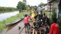 Seorang anggota TNI AD mengevakuasi anak korban banjir di kampung Petuk Katimpun Bawah, Palangkaraya, Kalteng. (Liputan6.com/ Marifka Wahyu)