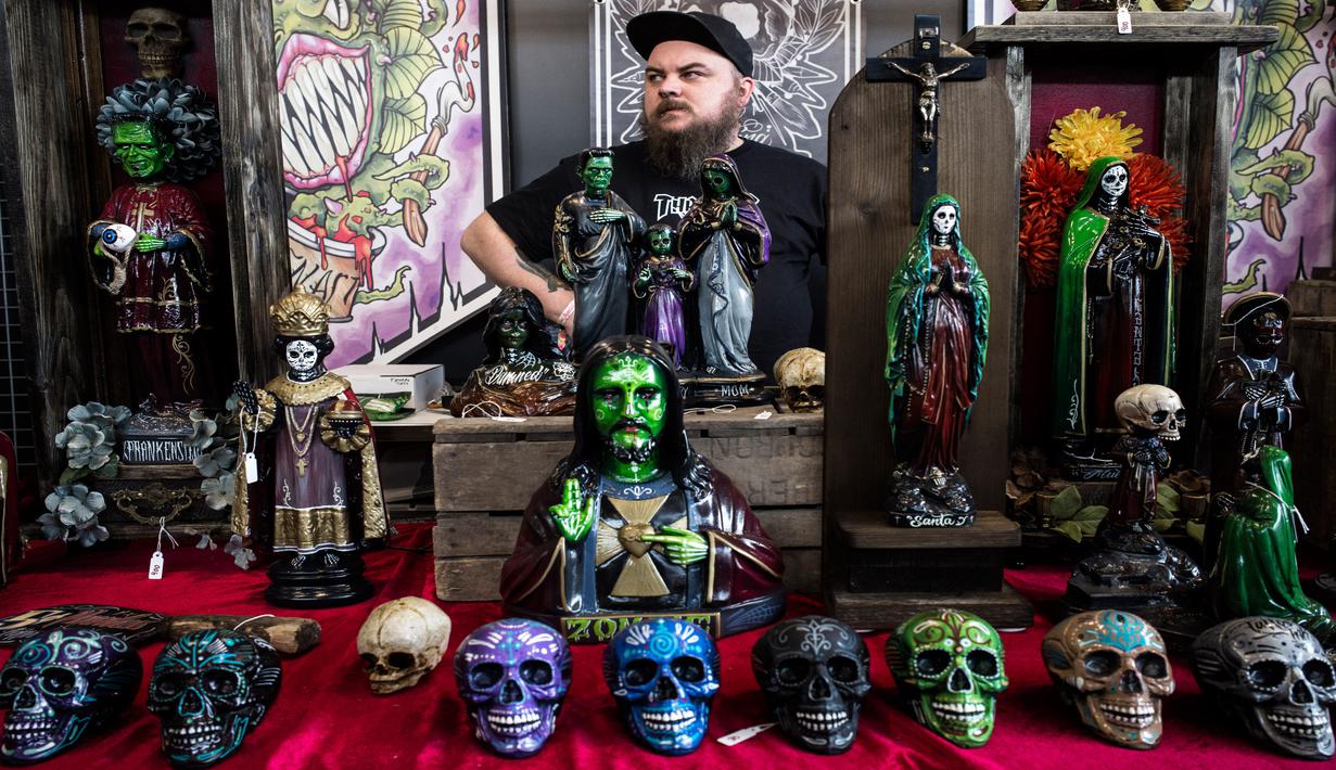 Seorang pria menjual patung di sebuah stan Paris Tattoo Convention di Grand Halle de la Villette, Paris, Prancis, Jumat (9/3). Paris Tattoo Convention tahun ini merupakan yang kedelapan. (Philippe LOPEZ/AFP)