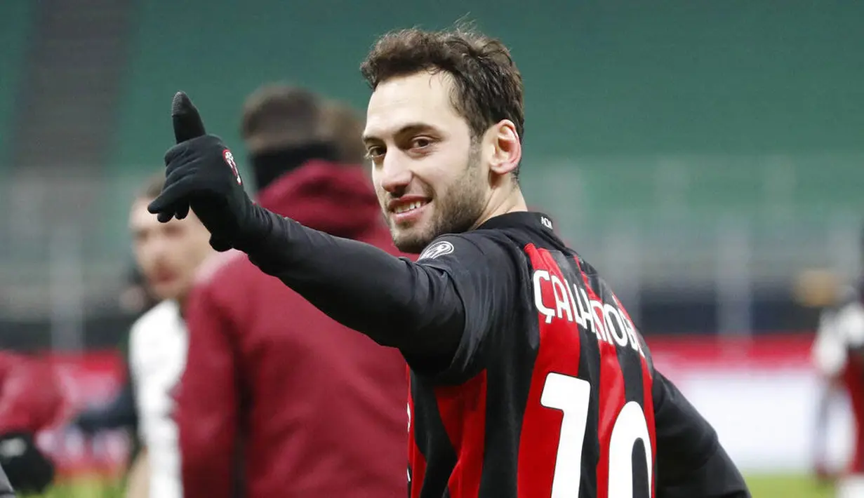 Pemain AC Milan, Hakan Calhanoglu, merayakan kemenangan atas Torino pada laga Coppa Italia di Stadion San Siro, Selasa (12/1/2021). AC Milan menang adu penalti dengan skor 5-4. (AP/Antonio Calanni)