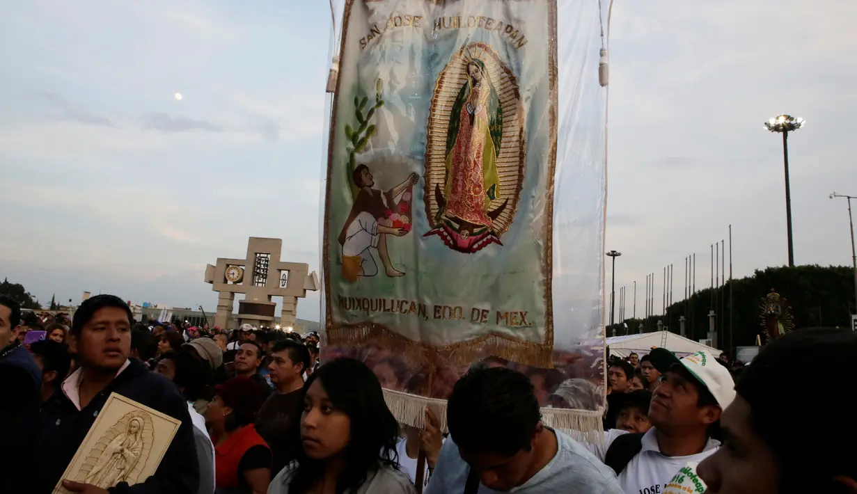Peziarah membawa gambar Bunda dari Guadalupe saat mereka tiba di kawasan Basilika Guadalupe di Mexico City, Meksiko (11/12). Ritual ziarah ini dilakukan setiap tahunnya untuk menghormati Bunda dari Guadalupe. (Reuters/Henry Romero)