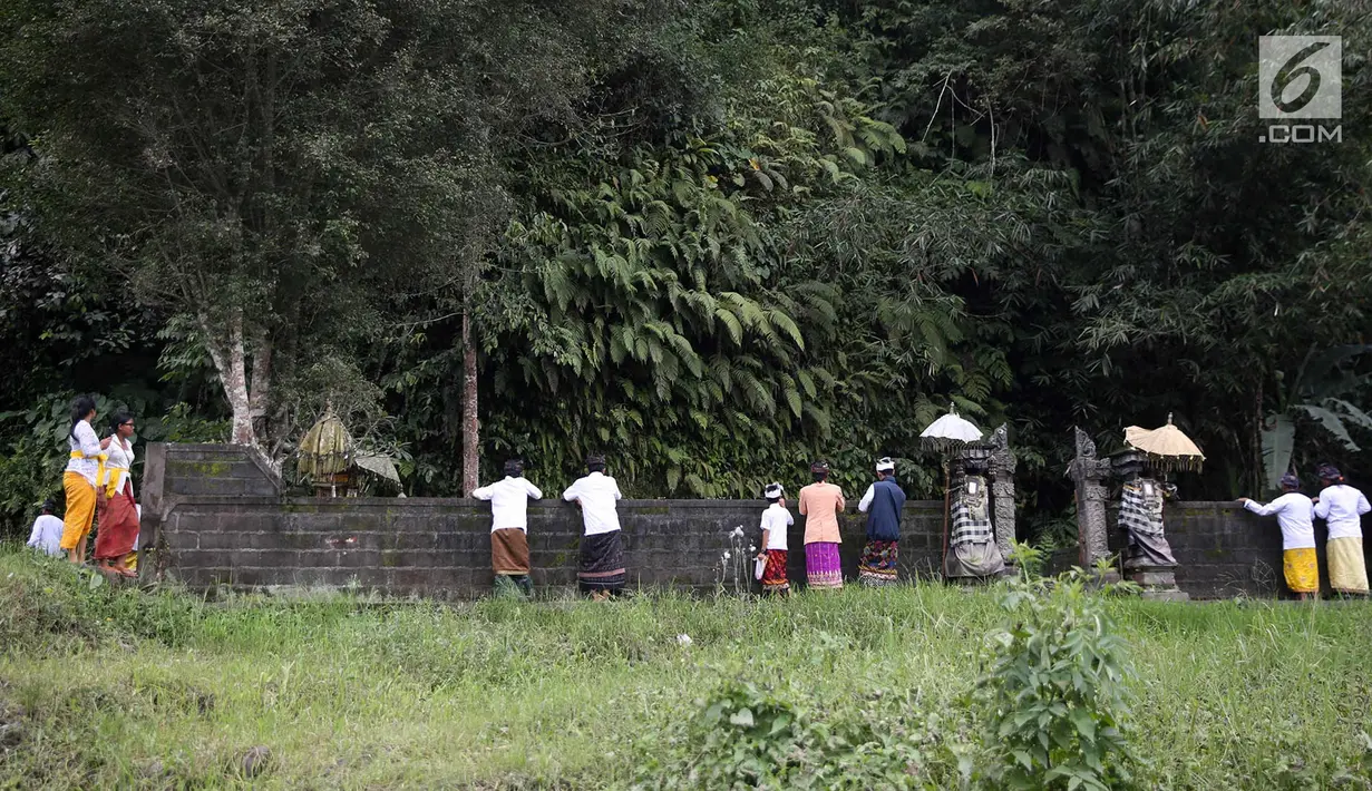Warga mengamati aliran lahar dingin saat akan beribadah di sekitar Sungai Yeh Sah, Karangasem, Bali, Jumat (1/12). Warga berharap diberi keselamatan dan berkah dari erupsi Gunung Agung yang terjadi. (Liputan6.com/Immanuel Antonius)