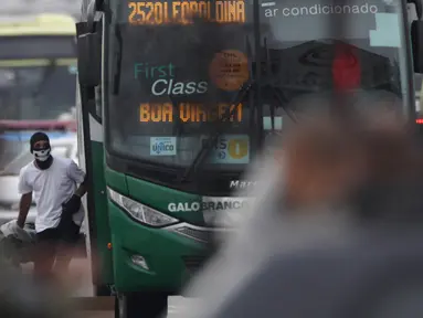 Seorang pria bersenjata menyandera puluhan orang dalam bus di sebuah jembatan yang menghubungkan Kota Niteroi dengan Rio de Janeiro, Brasil, Selasa (20/8/2019). Pria tersebut mengancam akan membakar kendaraan berisi 37 orang itu. (AP Photo/Ricardo Cassiano/Agencia O Dia)