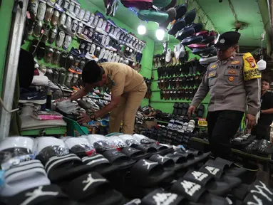 Petugas gabungan dari Satpol PP, kepolisian, dan Kelurahan Kota Bambu Selatan melakukan razia peredaran obat tramadol di kawasan KS Tubun, Tanah Abang, Jakarta Pusat, Selasa (13/10/2026). Razia ini dilakukan untuk mengawasi peredaran obat yang berpotensi disalahgunakan. (KLY/Budy Santoso)