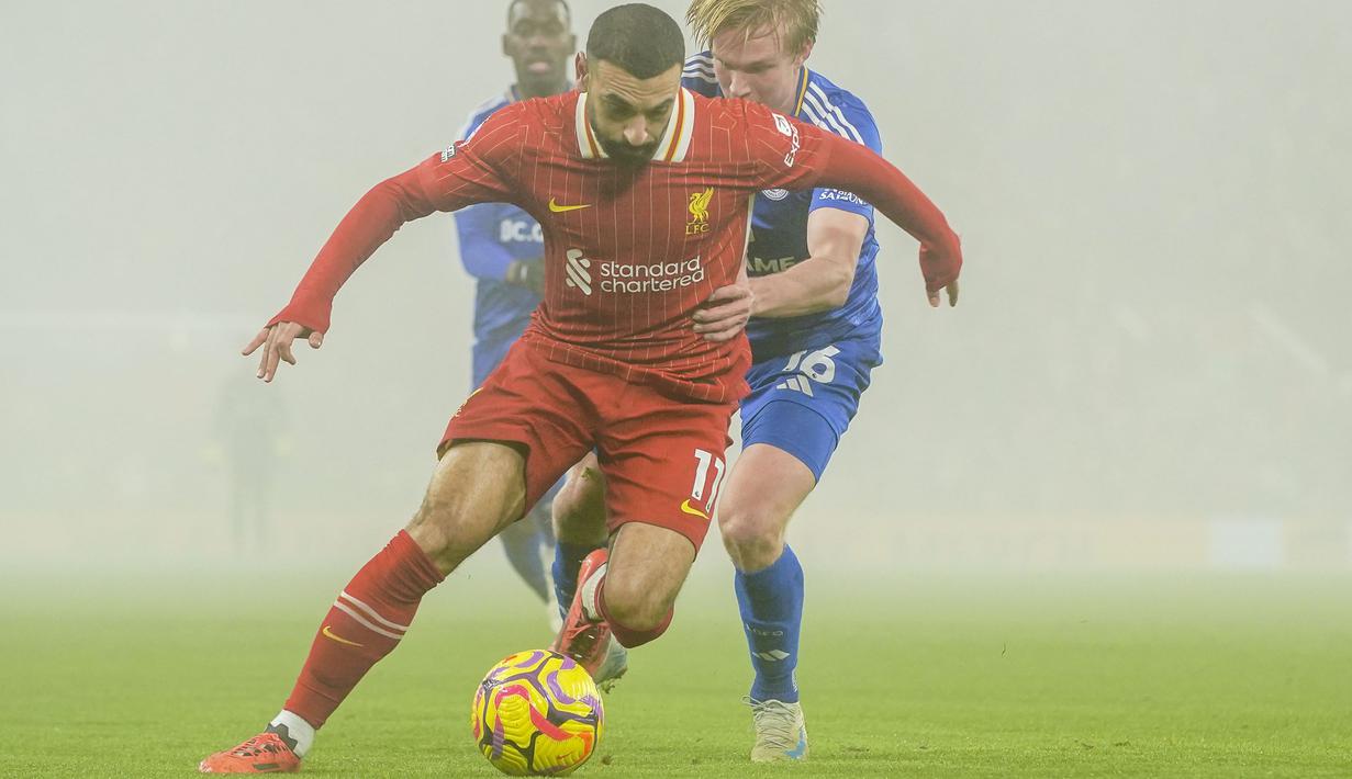 Pemain Liverpool, Mohamed Salah berebut bola dengan pemain Leicester, Victor Kristiansen dalam laga lanjutan Liga Inggris 2024/2025 di Anfield, Liverpool, Inggris, Jumat (27/12/2024) WIB. (AP Photo/PA/Peter Byrne)