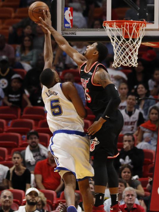 Pebasket Miami Heat, Jordan Mickey, berusaha memblok pebasket Golden State Warriors, Kevon Looney, pada laga NBA di American Airlines Arena, Miami, Senin (4/12/2017). Warriors menang 123-95 atas Heat. (AP/Joe Skipper)