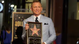 Daniel Craig berpose dengan replika bintang barunya di Hollywood Walk of Fame pada upacara penghargaan di Los Angeles, Rabu (6/10/2021). Craig menjadi bintang Bond keempat yang menerima bintang di Hollywood Walk of Fame setelah Roger Moore, David Niken, dan Pierce Brosnan. (AP Photo/Chris Pizzello)