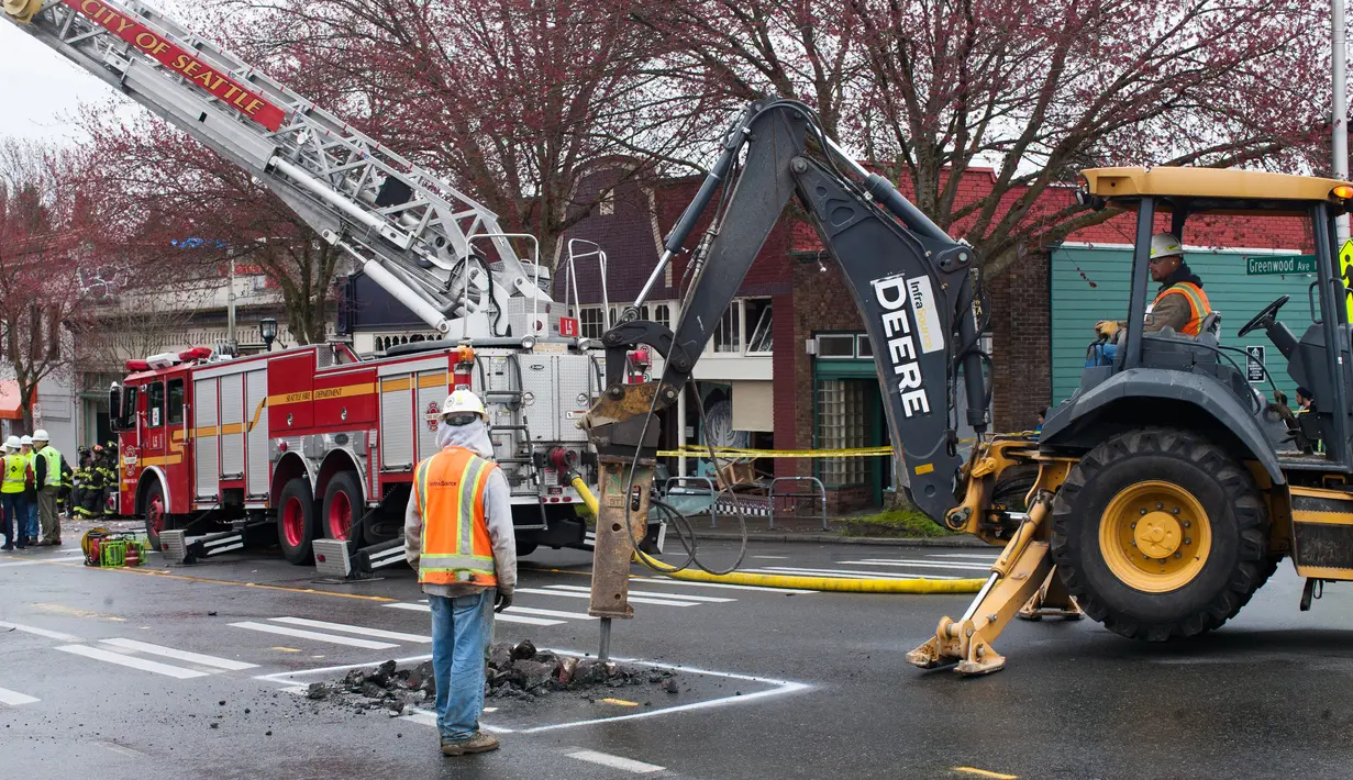 Petugas memperbaiki saluran gas setelah ledakan yang mengguncang jalan Greenwood, Washington, Rabu (9/3). Sembilan orang pemadam kebakaran mengalami luka-luka dan dilarikan ke rumah sakit akibat kejadian tersebut. (Matt Mills McKnight/Getty Images/AFP)