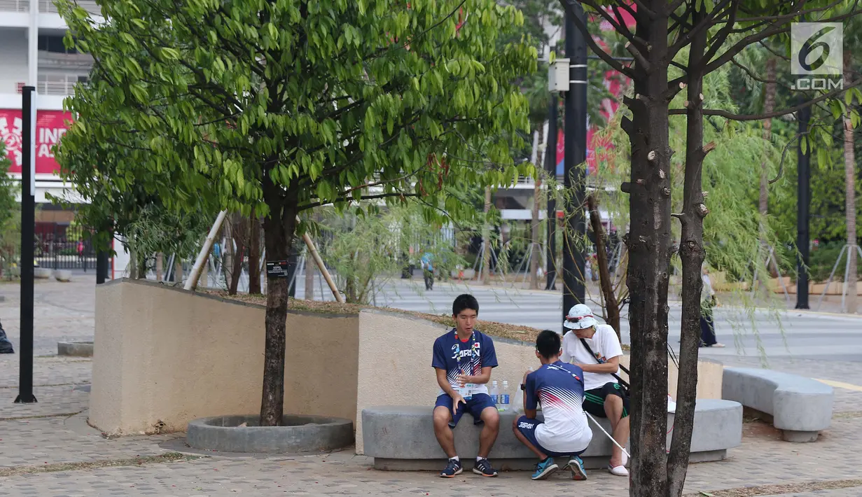 Beberapa atlet Asian Para Games 2018 asal Jepang duduk santai di taman dekatStadion Madya Kompleks Gelora Bung Karno, Jakarta, Kamis (11/10). Berbagai aktivitas dilakukan para atlet para atletik di luar arena. (Liputan6.com/Helmi Fithriansyah)