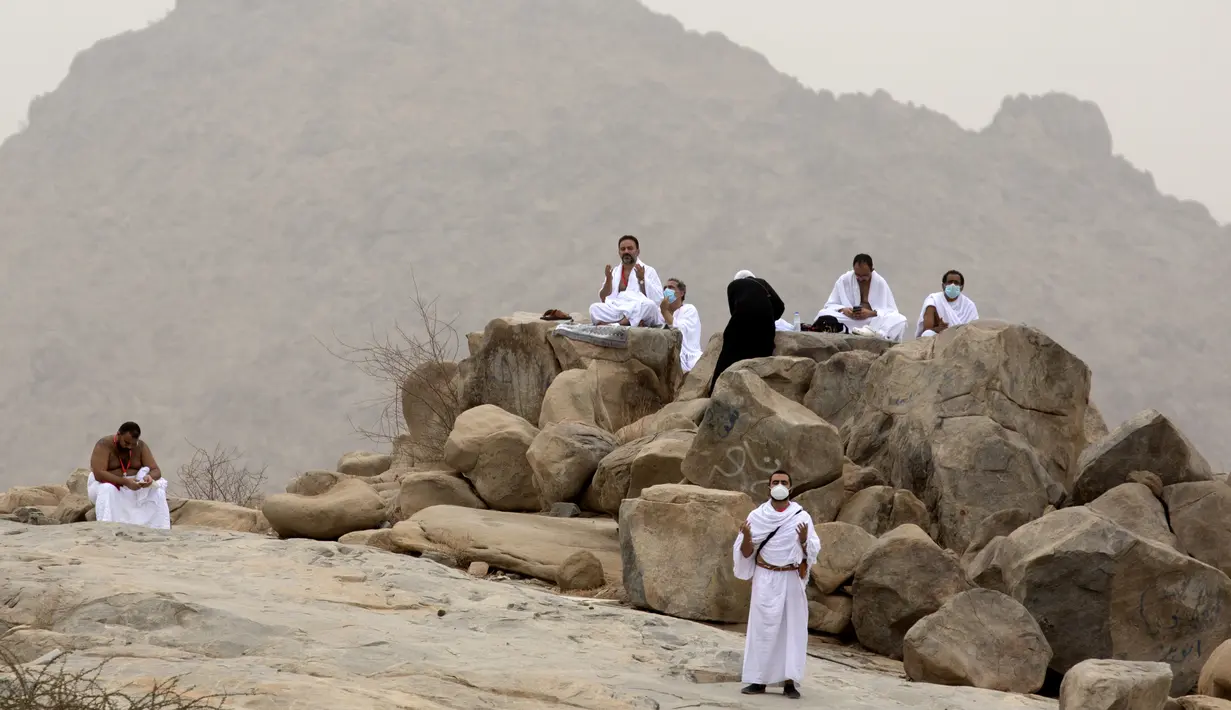 Jemaah berdoa di depan bukit batu saat akan menunaikan puncak ibadah haji, wukuf di Arafah selama ibadah haji di luar kota suci Mekah, Arab Saudi (19/7/2021). Sebelum menjalani ibadah puncak, para jemaah haji menghabiskan waktu dengan berdoa hingga matahari terbit. (AP Photo/Amr Nabil)
