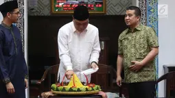 Wakil Ketua Umum DMI Komjen Pol Syafruddin didampingi Ketua Departemen Pemberdayaan Ekonomi dan Kewirausahaan DMI Erwin Aksa dan Ketum Ricma M Soekarno Hatta memotong tumpeng saat meresmikan Ricma Store, Jakarta, Jumat (9/3). (Liputan6.com/Arya Manggala)
