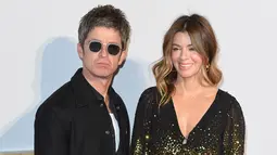 Musisi Inggris Noel Gallagher (kiri) dan istrinya Sara MacDonald berpose di karpet merah saat tiba untuk pemutaran perdana film Inggris "A Star is Born" di pusat Kota London, Inggris, 27 September 2018. Hubungan sang mantan gitaris Oasis ini dengan istrinya akhirnya berakhir juga. (Anthony HARVEY/AFP)