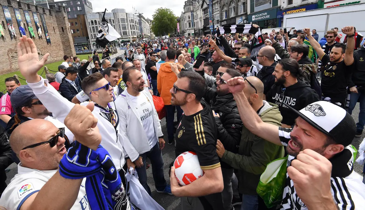 Sejumlah suporter Real Madrid dan Juventus saling meneriakkan slogan dukungan untuk tim kesayanganya di Cardiff (03/06/2017). Kedua suporter terlihat rukun jelang pertandingan final liga Champions. (EPA/Daniel Dal Zennaro)