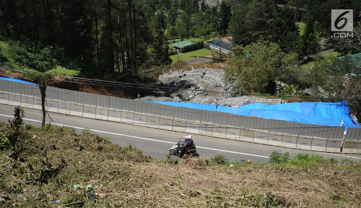 Pemotor melintas di sekitar area yang longsor di kawasan Ciloto, Cianjur, Jawa Barat, Sabtu (31/3). Longsor yang terjadi pada Rabu (28/3) lalu diduga adanya pergerakan tanah sehingga menyebabkan longsor. (Liputan6.com/Helmi Fithriansyah)